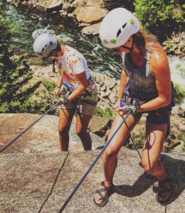 Two Girls Rock Climbing over River